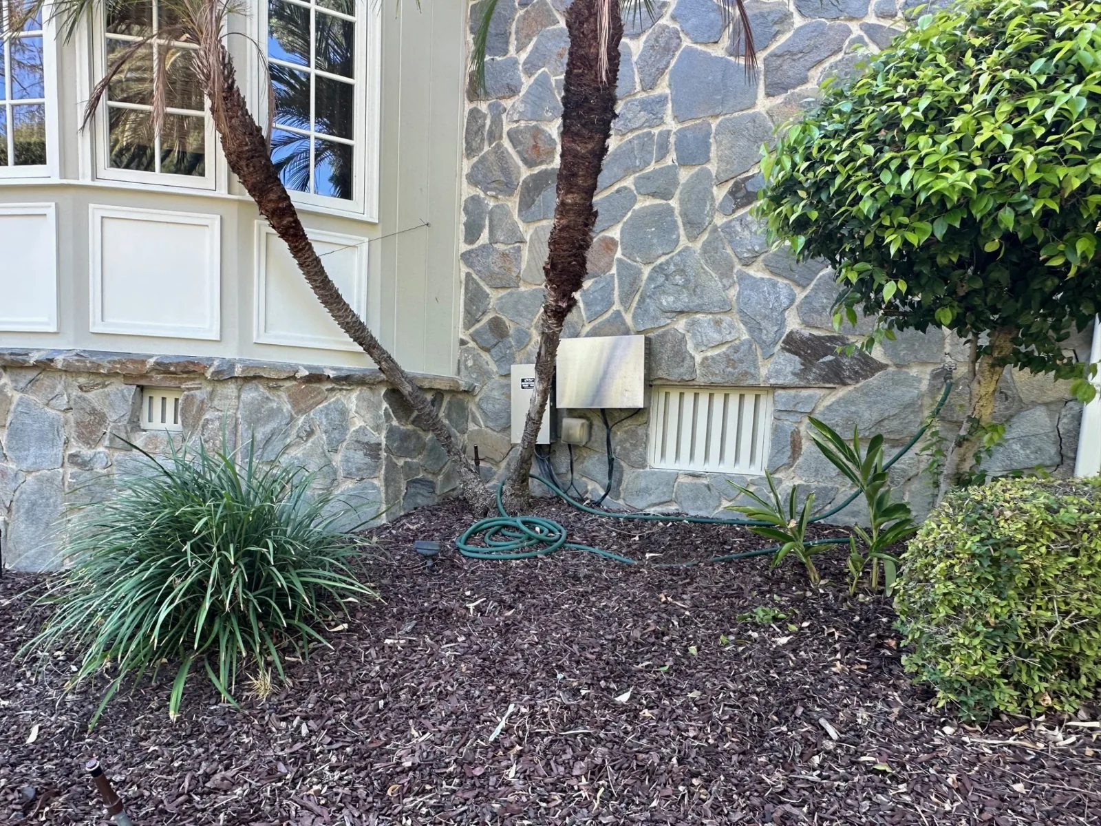Ember-resistant foundation vent set into a stone wall