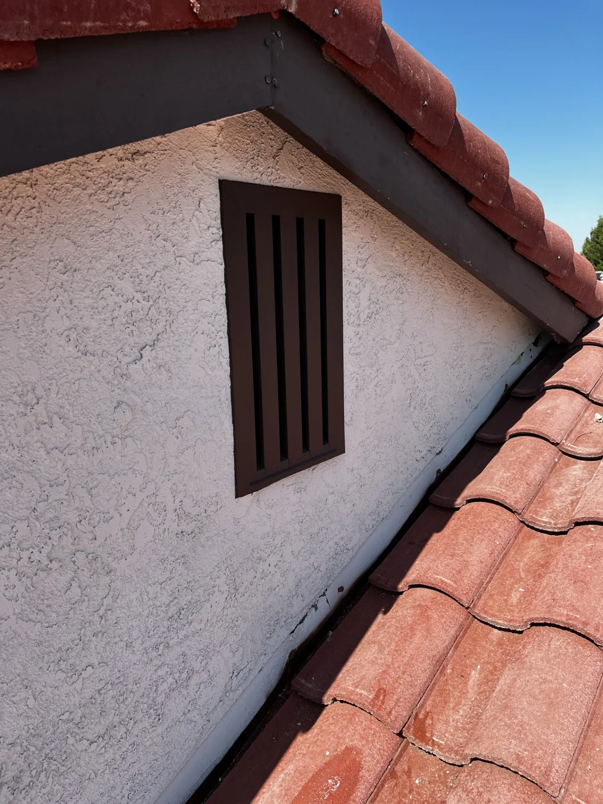 Ember-resistant gable vent on a Spanish-style California home