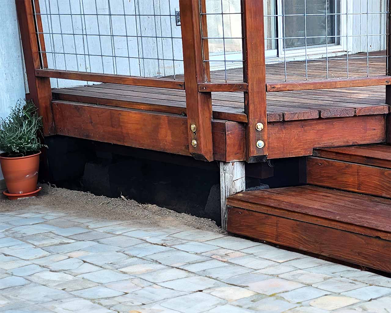 Ember-resistant mesh installed as skirting under a wood deck