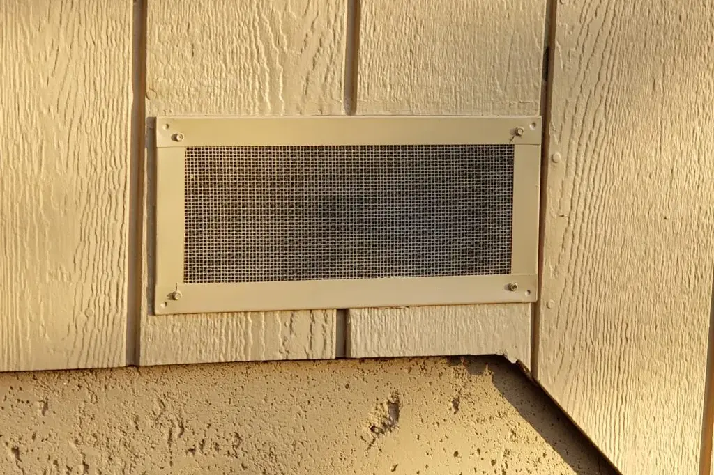 Ember-resistant metal mesh installed over a foundation vent